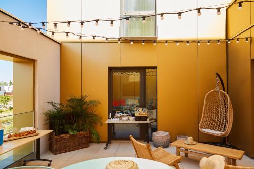 a patio with a table and chairs and lights at Ibis Styles Montpellier Aéroport Parc Des Expos in Mauguio