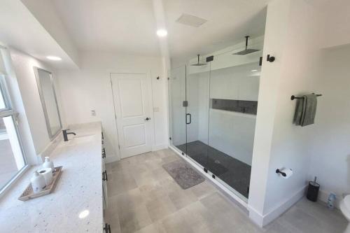 baño con ducha y puerta de cristal en Remodeled 4BR Pool Home/IMG Golf View/Near Beaches, en Bradenton