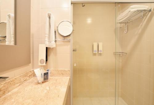 a bathroom with a shower with a glass door at Gandini Hotel in Itu