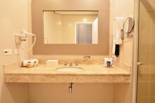 a bathroom with a sink and a mirror at Gandini Hotel in Itu
