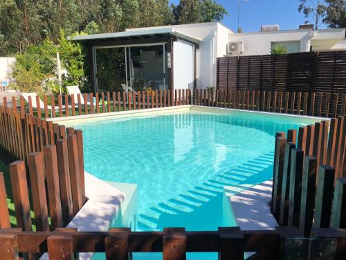 a swimming pool in a backyard with a wooden fence at Villas do Rosal in Boa Vista de Cima