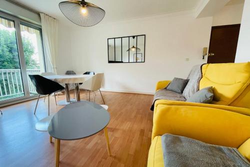 uma sala de estar com um sofá amarelo e uma mesa em La Belle Ferronnière appartement avec environnement paisible em Amboise