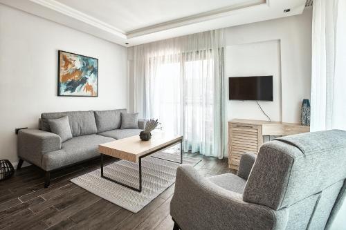 ein Wohnzimmer mit einem Sofa und einem TV in der Unterkunft Casa Mimosa Hotel in Izmir