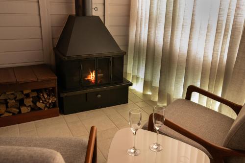 two wine glasses on a table in front of a fireplace at Resort Ecoar in Gaspar