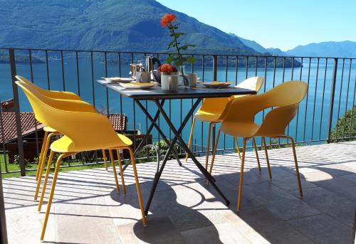 a table and chairs on a balcony with a view of the water at Ca' del Barba in Domaso