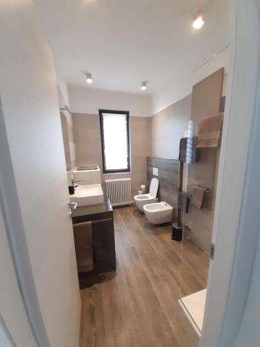 a bathroom with two sinks and a toilet and a mirror at Ca' del Barba in Domaso