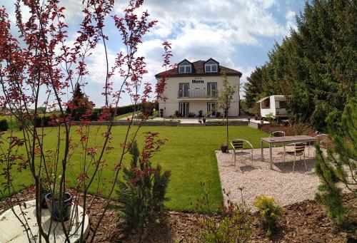 ein großes Haus mit einem Hof mit einem Picknicktisch in der Unterkunft Hotel BRADA in Jičín