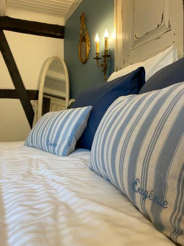 a bed with blue and white pillows on it at La Ferme de Grand Mère in Furchhausen