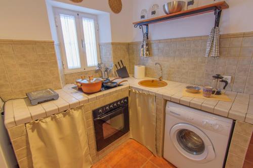 uma cozinha com um lavatório e uma máquina de lavar roupa em Apartamento El Socorro em Ronda