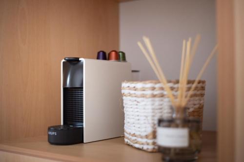 a coffee maker sitting on a shelf next to a basket at Nysa Residence in Andros