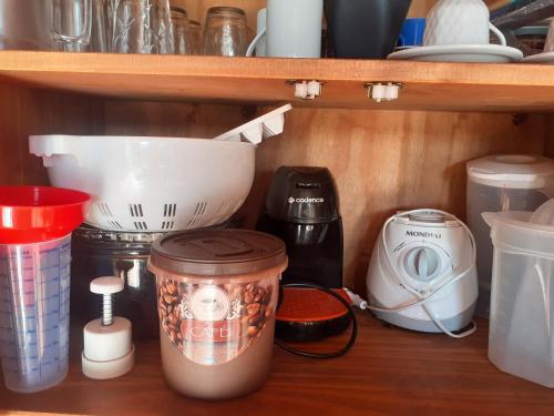 a shelf with various kitchen utensils on it at Pousada Acolhedora in Ribeirão Preto