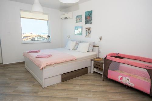 1 dormitorio pequeño con 1 cama y TV en Luxury House In Chervenka next to Gradina beach, en Chernomorets