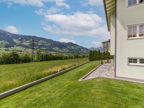 ein Haus mit grünem Rasen neben einem Gebäude in der Unterkunft ZillertalAppartements Günter in Hart im Zillertal