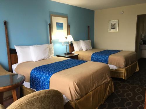una camera d'albergo con due letti e una sedia di Travel Inn a Marston