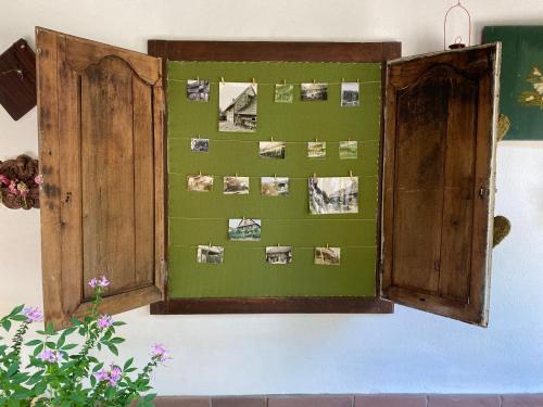 a green wall with pictures on it with a wooden door at La Ferme de Grand Mère in Furchhausen