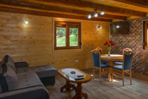 ein Wohnzimmer mit einem Sofa und einem Tisch in der Unterkunft Brvnara Greben in Timotijevići
