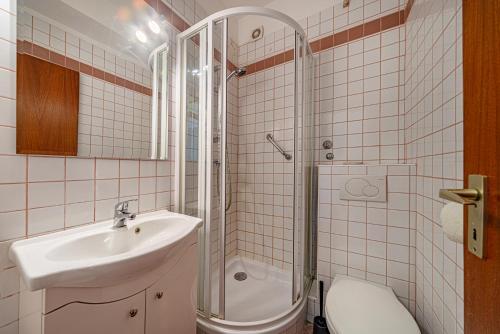 a bathroom with a sink and a shower and a toilet at Hotel Bobbio in Budapest