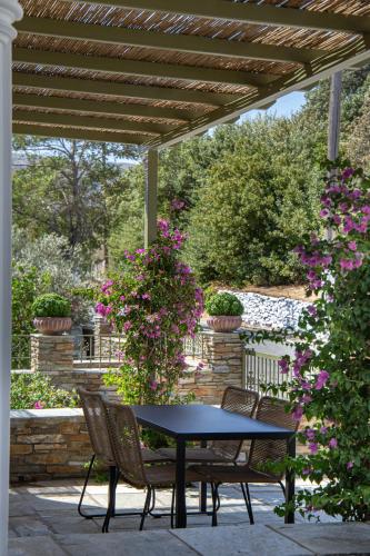 a table and chairs on a patio with flowers at Nysa Residence in Andros