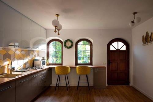 a kitchen with two bar stools and two windows at Holiday Home in Sinaia in Sinaia