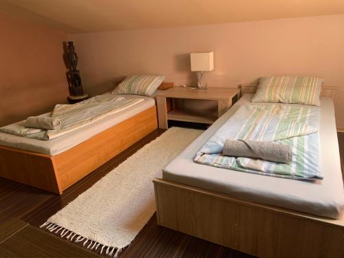 two twin beds in a room with a night stand at Pláza Home in Siófok