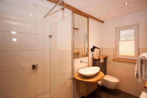 a bathroom with a sink and a glass shower at Hotel Kleins Wiese in Schmallenberg