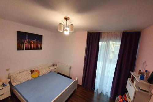 a bedroom with a bed and a large window at Home sweet home in Cluj-Napoca