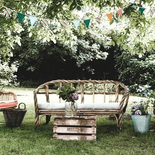 a wooden bench sitting in the grass with flowers on it at Bed & Breakfast Neeltje Soet in Mierlo