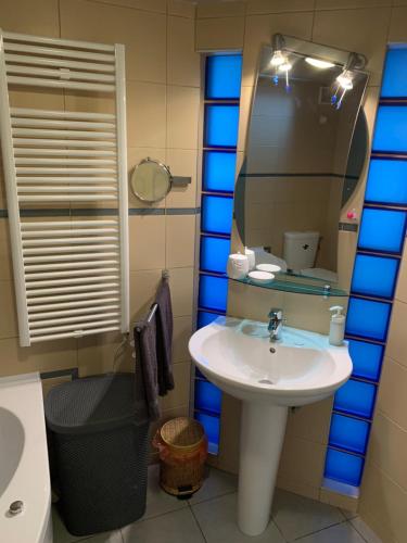 a bathroom with a sink and a mirror at Pláza Home in Siófok