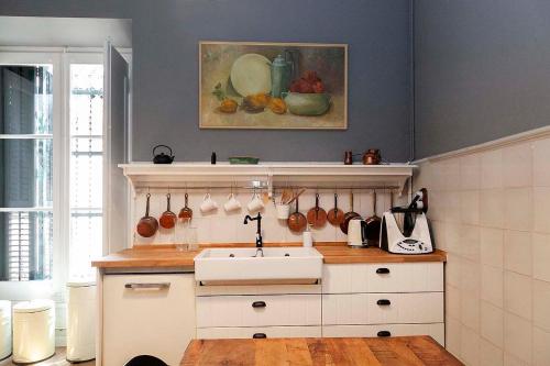a kitchen with a sink and a painting on the wall at A historic XVI century beach home near Barcelona in Barcelona