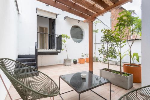a balcony with a glass table and chairs at Soy Local Primavera in Medellín