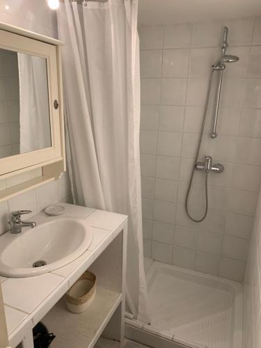 une salle de bain blanche avec une douche et un lavabo dans l'établissement Au 10, à LʼIsle-sur-la-Sorgue