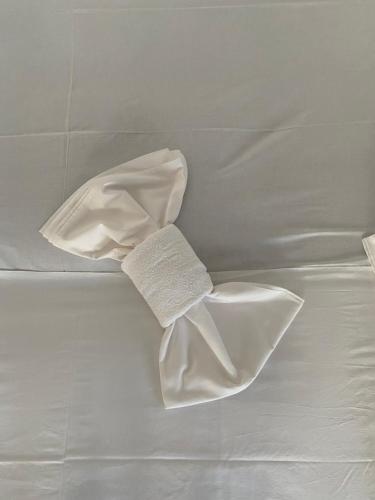 a white towel sitting on top of a bed at Overwave Apartment in Kavála