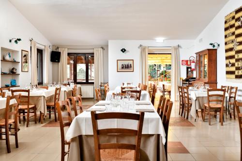 a dining room with white tables and chairs at S'Enis Monte Maccione in Oliena