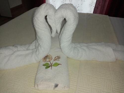 two towels shaped like swans sitting on a bed at Apartman TAJNA Vrdnik in Vrdnik