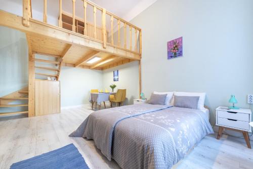 a bedroom with a bed and a wooden staircase at Central Studio Budapest in Budapest