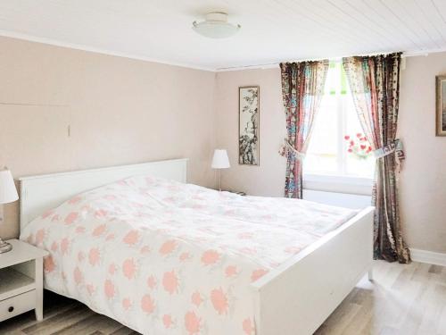 1 cama blanca en un dormitorio con ventana en Holiday home SÖLVESBORG XI, en Sölvesborg