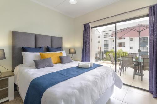 a bedroom with a large bed and a balcony at Villa Valentino Greenstone Ridge WiFiNetflix in Edendale