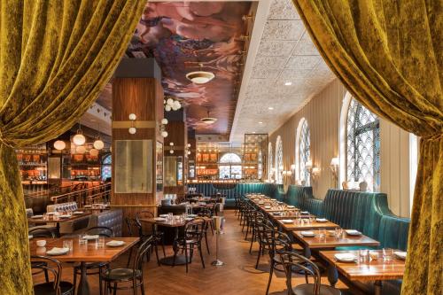 a dining room with tables and chairs and windows at Hotel Bijou - Union Square in San Francisco
