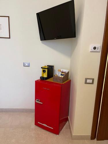 a red refrigerator with a flat screen tv on a wall at B&B Ponte Capograssi in Sulmona