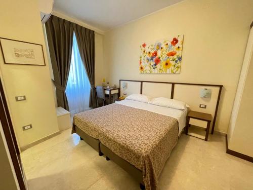 a bedroom with a bed and a painting on the wall at B&B Ponte Capograssi in Sulmona