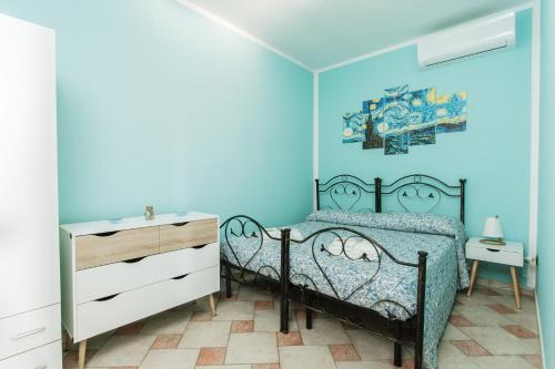 a blue bedroom with a bed and a dresser at Villa Nicole Vista Mare in Andrano