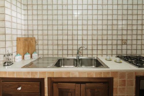 a kitchen counter with a sink and a stove at Villa Nicole Vista Mare in Andrano