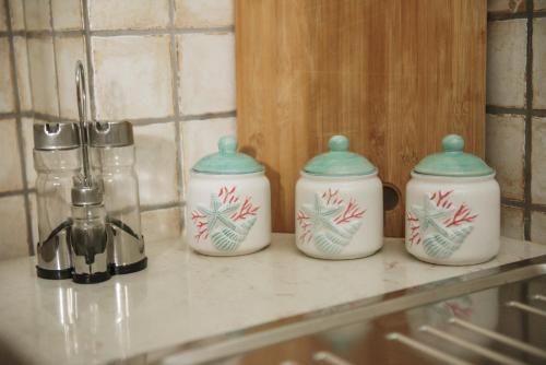 a group of four kettles sitting on a counter at Villa Nicole Vista Mare in Andrano