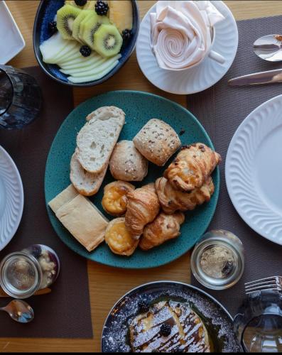 a table with plates of bread and pastries on it at Douro Castelo Signature Hotel & Spa in Lamego