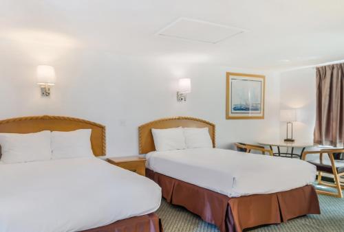 um quarto de hotel com duas camas e uma mesa em America's Best Value Inn & Suites/Hyannis em Hyannis