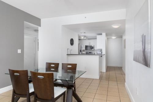 a dining room with a glass table and chairs at Fortune House Hotel Suites in Miami