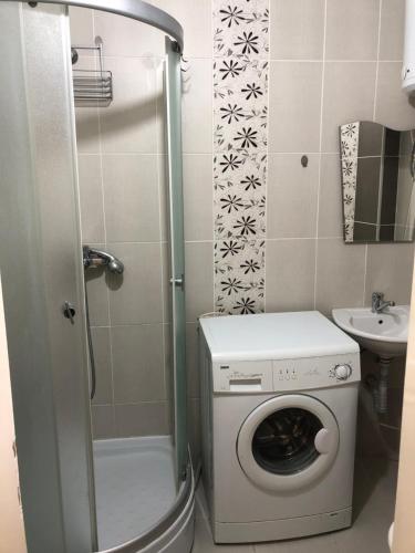 a small bathroom with a washing machine and a sink at Square Vanilla Apartments in Skopje