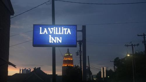 a sign that reads la willilitia inn with a building in the background at La Villita Inn in San Antonio