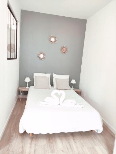 a bedroom with a white bed with two mirrors on the wall at Aéroport Roissy CDG - Parc Astérix - Parc des expositions in Louvres