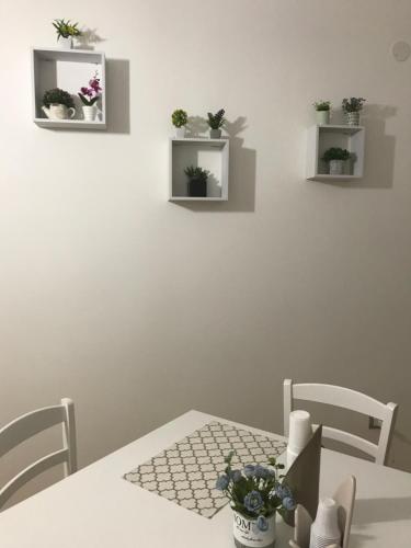 a white table with chairs and plants on the wall at B&B Marrelli Crotone in Crotone